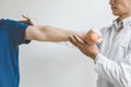 Physiotherapist man giving exercise with dumbbell treatment About Arm and Shoulder of athlete male patient Physical therapy Royalty Free Stock Photo