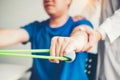 Physiotherapist man giving resistance band exercise treatment About Arm and Shoulder of athlete male patient Physical therapy Royalty Free Stock Photo