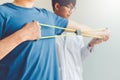 Physiotherapist man giving resistance band exercise treatment About Arm and Shoulder of athlete male patient Physical therapy Royalty Free Stock Photo