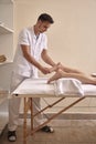Physiotherapist massage woman feet, full length shot.