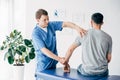 Physiotherapist massaging arm of patient on massage table Royalty Free Stock Photo