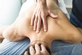 Physiotherapist massaging the back and neck of a young man. Concept of wellness and physiotherapy