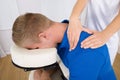 Physiotherapist massaging man's shoulder