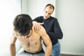 Physiotherapist massaging a young man shoulder.Physiotherapy