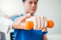 Physiotherapist man giving exercise with dumbbell treatment About Arm and Shoulder of athlete male patient Physical therapy Royalty Free Stock Photo