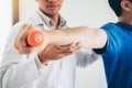 Physiotherapist man giving exercise with dumbbell treatment About Arm and Shoulder of athlete male patient Physical therapy Royalty Free Stock Photo