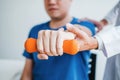 Physiotherapist man giving exercise with dumbbell treatment About Arm and Shoulder of athlete male patient Physical therapy Royalty Free Stock Photo