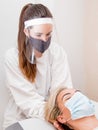 Female physiotherapist performing a massage with protections for the virus