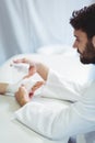 Physiotherapist putting bandage on injured hand of patient Royalty Free Stock Photo