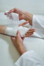 Physiotherapist putting bandage on injured hand of patient Royalty Free Stock Photo