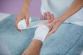 Physiotherapist putting bandage on injured hand of patient Royalty Free Stock Photo