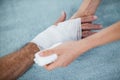 Physiotherapist putting bandage on injured hand of patient Royalty Free Stock Photo