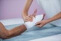 Physiotherapist putting bandage on injured hand of patient Royalty Free Stock Photo