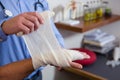 Physiotherapist putting bandage on injured hand of patient Royalty Free Stock Photo