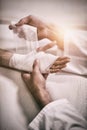 Physiotherapist putting bandage on injured hand of patient Royalty Free Stock Photo