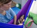 physiotherapist rehabilitate girl in hammock made of elastic material. sensory integration and correctional Royalty Free Stock Photo
