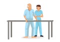 Physiotherapist standing by an old patient walking during a rehabilitation therapy