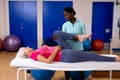 Physiotherapist stretching active senior woman leg in sports center Royalty Free Stock Photo