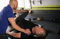 Physiotherapist stretching mature, elderly man, strength rehabilitation