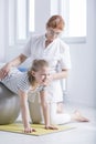 Physiotherapist supporting girl with scoliosis