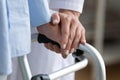 Physiotherapist touches woman hand while she holding walking frame closeup Royalty Free Stock Photo