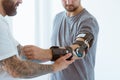 Physiotherapist who puts an orthosis on the hand of a young patient after an accident Royalty Free Stock Photo