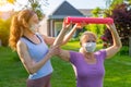 Physiotherapist working with elderly patient outdoors both wearing medical masks Royalty Free Stock Photo