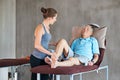 Physiotherapy, knee pain and senior man consulting physiotherapist for leg, injury or mobility in examination room Royalty Free Stock Photo