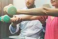 Physiotherapy - physiotherapist help woman patient to recover from hand injury. dumbbell exercises