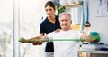 Physiotherapy, senior man and doctor exercise, resistance band and workout for muscle rehabilitation in a clinic Royalty Free Stock Photo