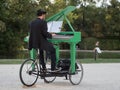 Pianist with a Hat Playing a Green Mobile Piano in a Public Park