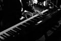 A pianist musician is performing and playing some nice music by using a piano keyboard on a stage at some nightclub or pub with