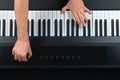 Pianist playing electric piano while modifying settings Royalty Free Stock Photo