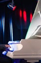 Pianist playing on grand white concert piano illuminated by colored spotlights. Royalty Free Stock Photo