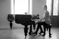 Pianist woman playing forte-piano in front the window at the castle. Women equality and achievements concept. black and white