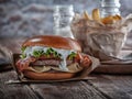 Piano burger with bacon and cutlet with cheese, tomato, greens.