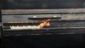 Black piano in flames slow motion