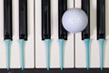 Piano keyboard and different golf balls and tees Royalty Free Stock Photo