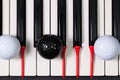 Piano keyboard and different golf balls and tees Royalty Free Stock Photo