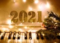 Piano keyboard with garlands of lights and Golden numbers 2021. Merry Christmas and New year concept Royalty Free Stock Photo