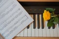 Piano keyboard with music book and yellow rose Royalty Free Stock Photo
