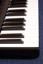 Piano keyboard with white and black keys on blue cotton background Royalty Free Stock Photo