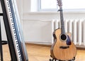 Piano keys and acoustic guitar in the interior of a bright room. Royalty Free Stock Photo