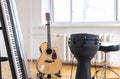 Piano keys and acoustic guitar in the interior of a bright room. Royalty Free Stock Photo