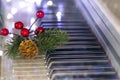 piano keys with golden cone, christmas tree branch and red berries on bokeh background. New Year or Christmas music Royalty Free Stock Photo