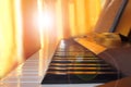 Piano keys before piano lessons at home, close up in the sun`s rays, toned