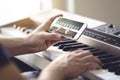 Piano lesson online. Man watching video tutorial with mobile phone and practising playing. Person learning to play an instrument.