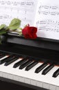 Piano with Sheet Music and a Rose