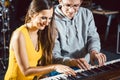 Piano teacher giving music lessons to his student