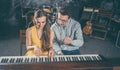 Piano teacher giving music lessons to his student